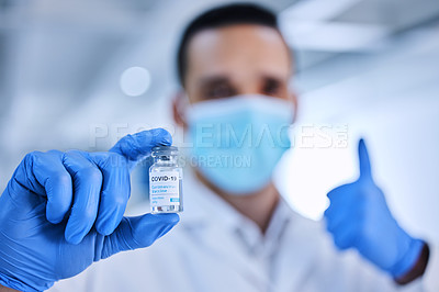 Buy stock photo Cropped shot of an unrecognizable male scientist holding up a bottle of the covid 19 vaccine