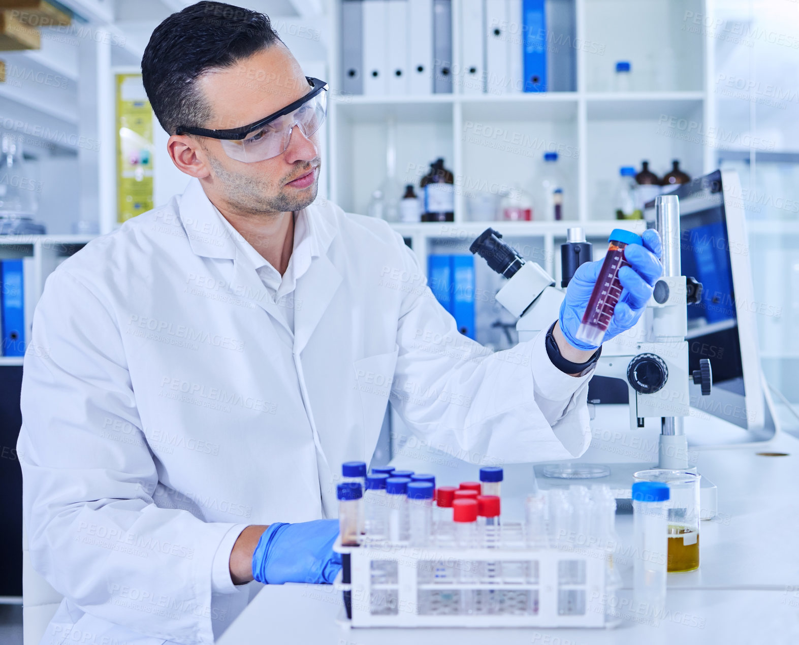 Buy stock photo Cropped shot of a handsome young male scientist working with medical samples in his lab