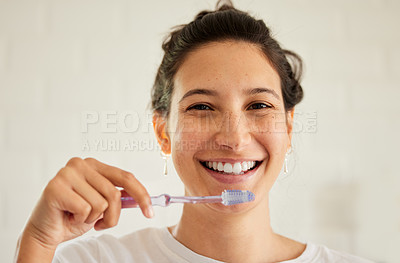 Buy stock photo Shot of a young woman brushing her teeth