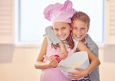 Buy stock photo Shot of an adorable little girl bonding with her brother at home while baking