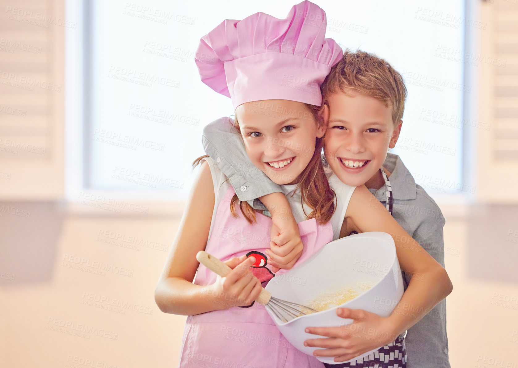 Buy stock photo Shot of an adorable little girl bonding with her brother at home while baking