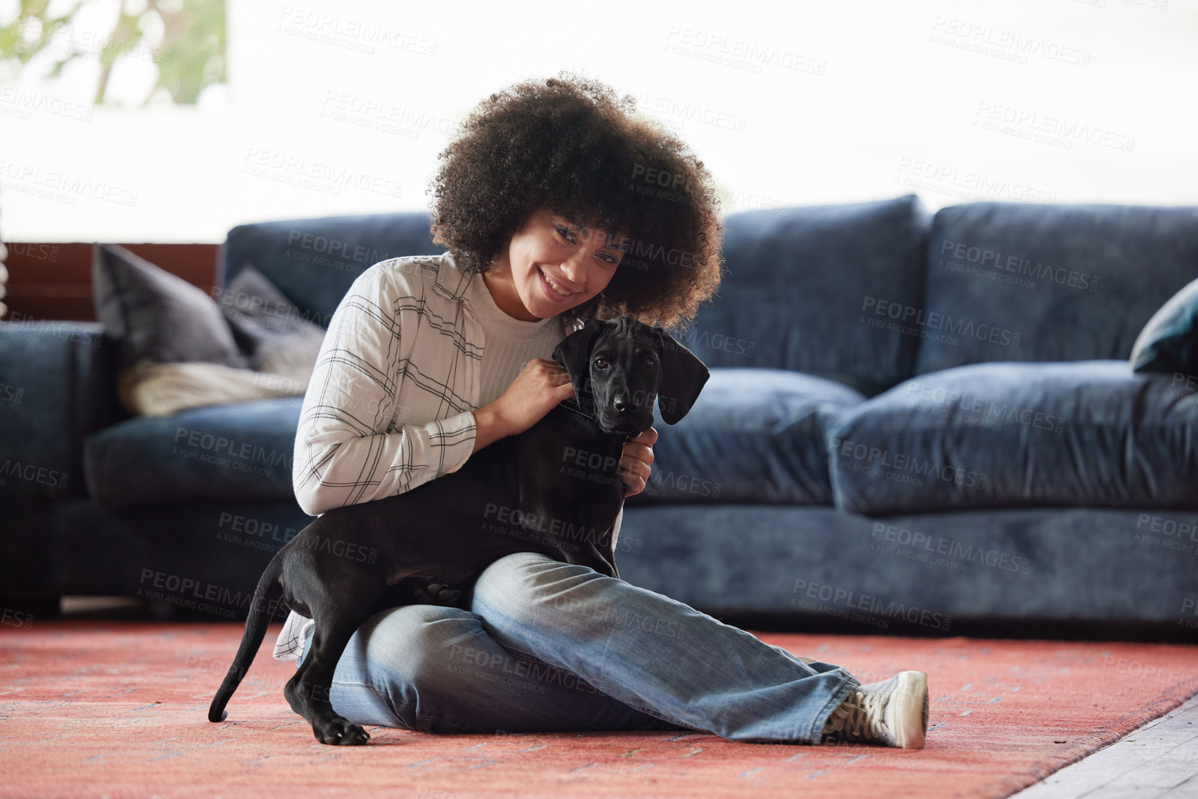 Buy stock photo Shot of a young woman playing with her dog at home