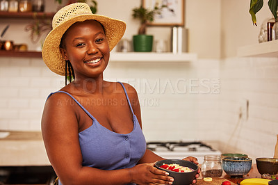 Buy stock photo Portrait of a young beautiful woman wearing a sunhat while preparing breakfast at home in the kitchen