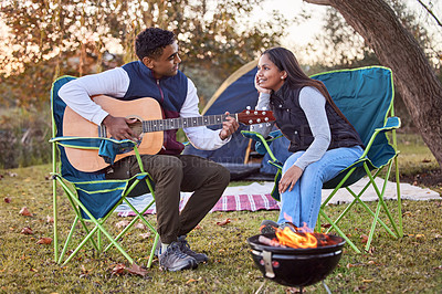 Buy stock photo Music, camping and couple with guitar in nature for romantic vacation, adventure or holiday. Love, singing and young man and woman playing song with string instrument by fire on outdoor weekend trip.