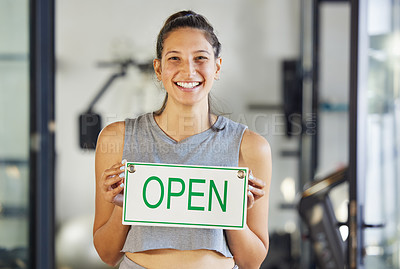 Buy stock photo Shot of a young gym instructor holding up a 