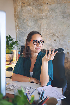 Buy stock photo Shot of an attractive young woman sitting alone and using her cellphone while working from home