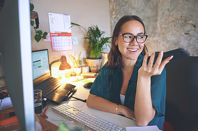 Buy stock photo Shot of an attractive young woman sitting alone and using her cellphone while working from home