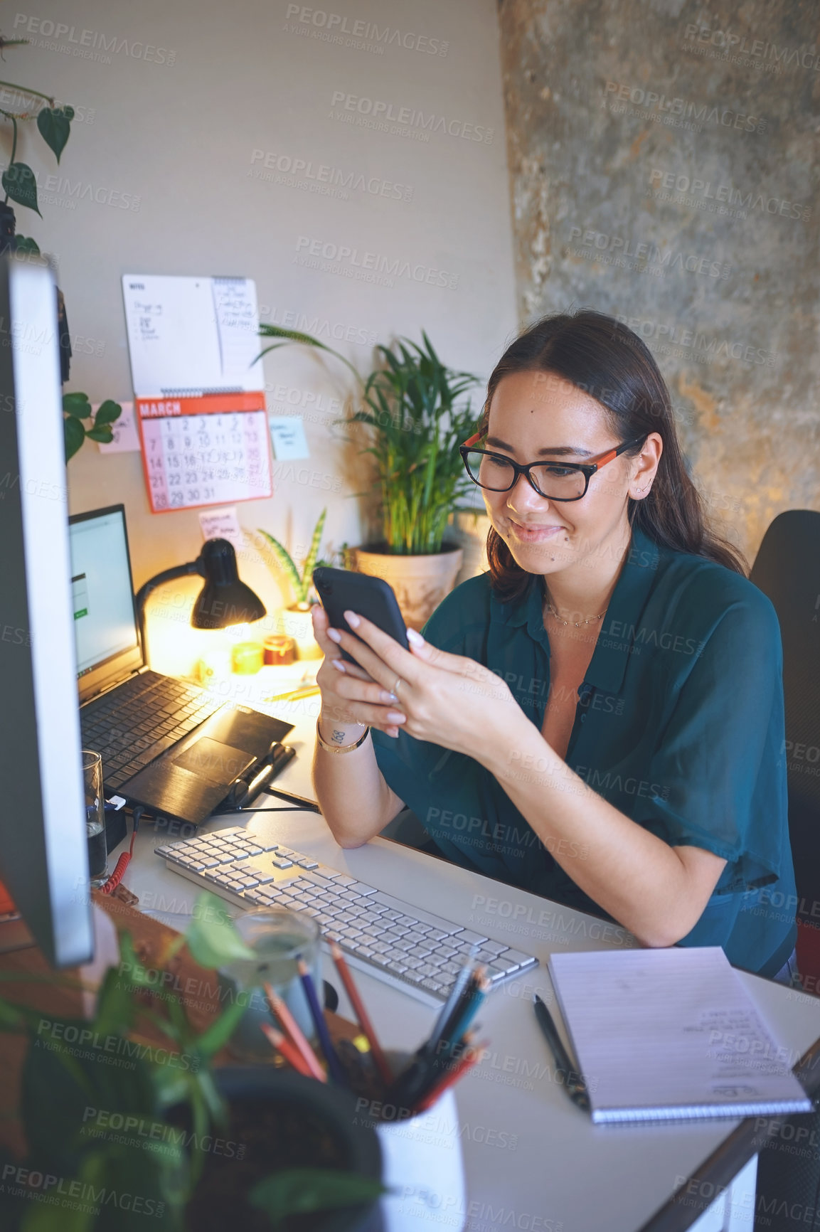 Buy stock photo Shot of an attractive young woman sitting alone and using her cellphone to work from home