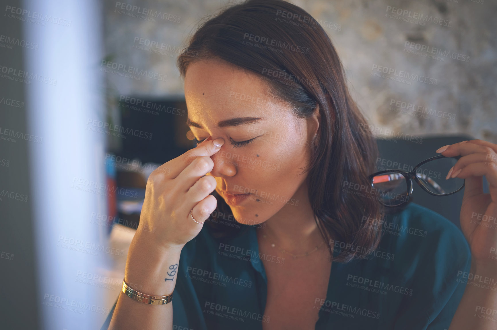 Buy stock photo Shot of an attractive young woman sitting alone and feeling stressed while using her computer to work from home