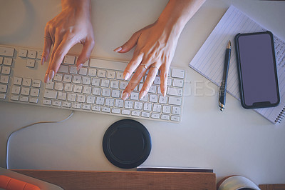 Buy stock photo High angle shot of an unrecognizable woman sitting alone and using her computer to work from home