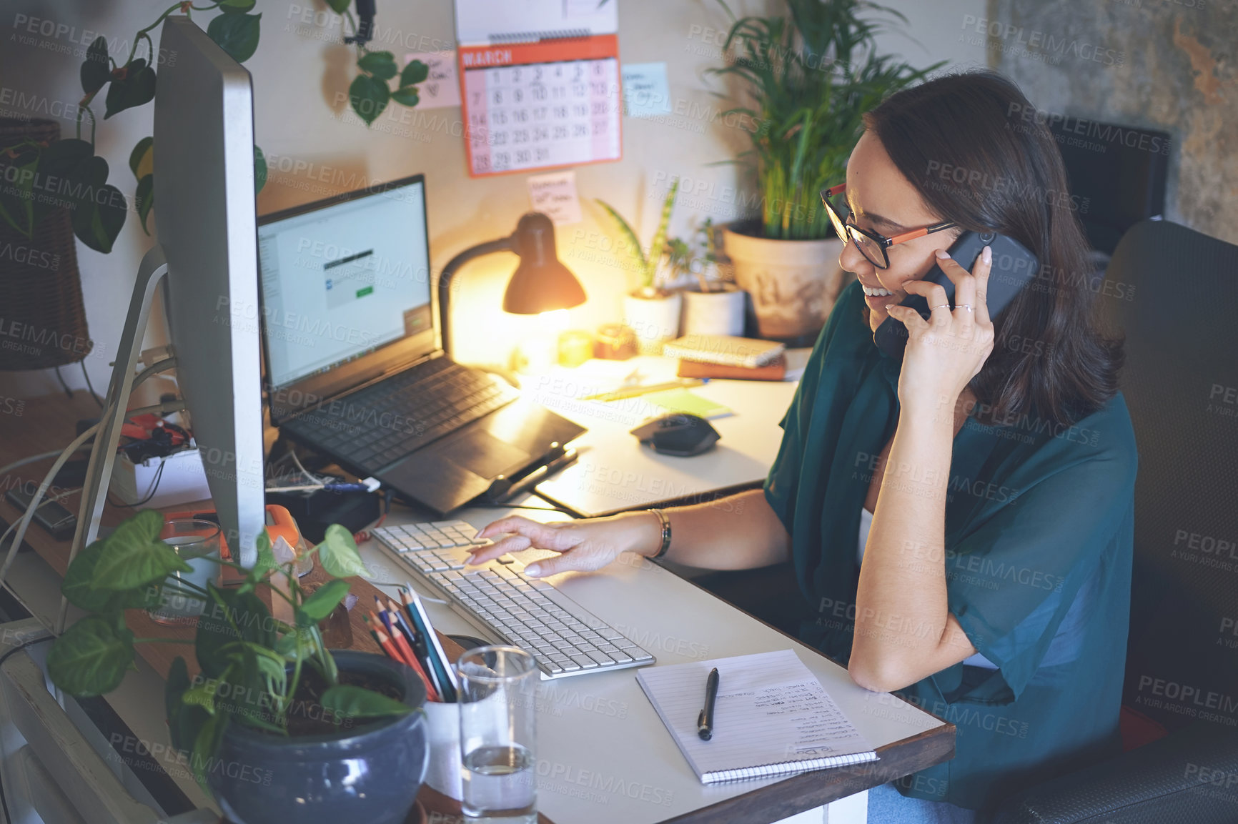 Buy stock photo Shot of an attractive young woman sitting alone and using technology while working from home