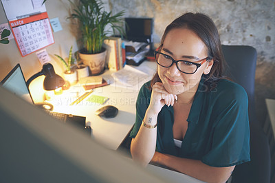 Buy stock photo Shot of an attractive young woman sitting alone and using her computer to work from home