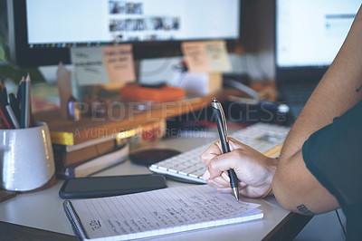 Buy stock photo Cropped shot of an unrecognizable woman sitting alone and writing notes while working from home