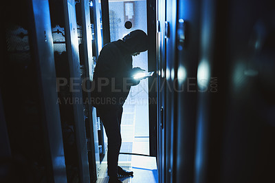 Buy stock photo Shot of a hacker using a digital tablet in a server room