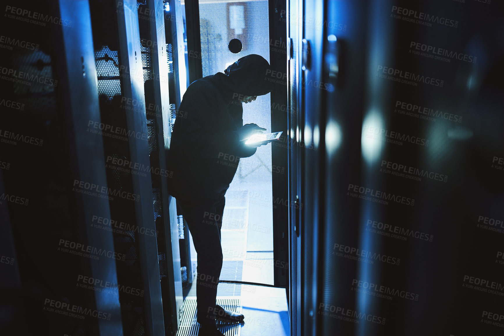 Buy stock photo Shot of a hacker using a digital tablet in a server room