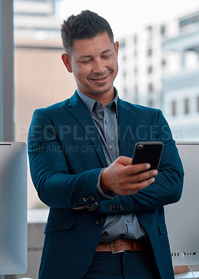 Buy stock photo Shot of a young man using a cellphone in the office