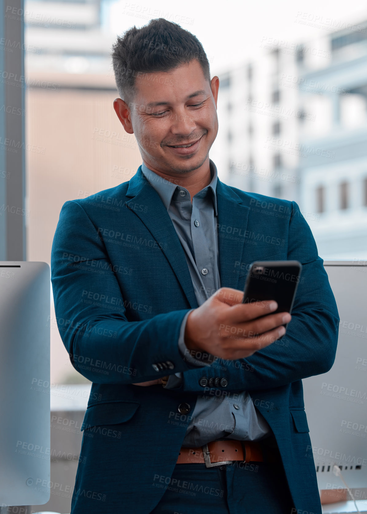 Buy stock photo Shot of a young man using a cellphone in the office