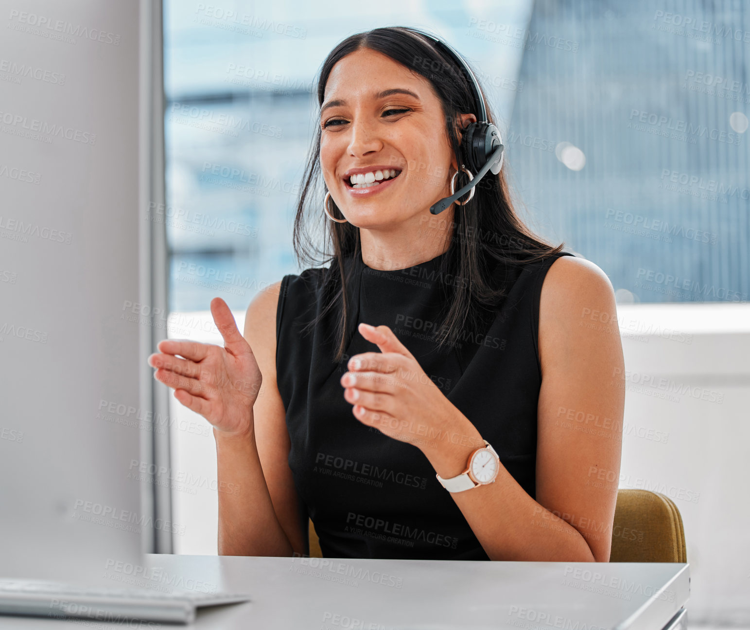Buy stock photo Shot of a young woman using a headset and computer
at work in a modern office