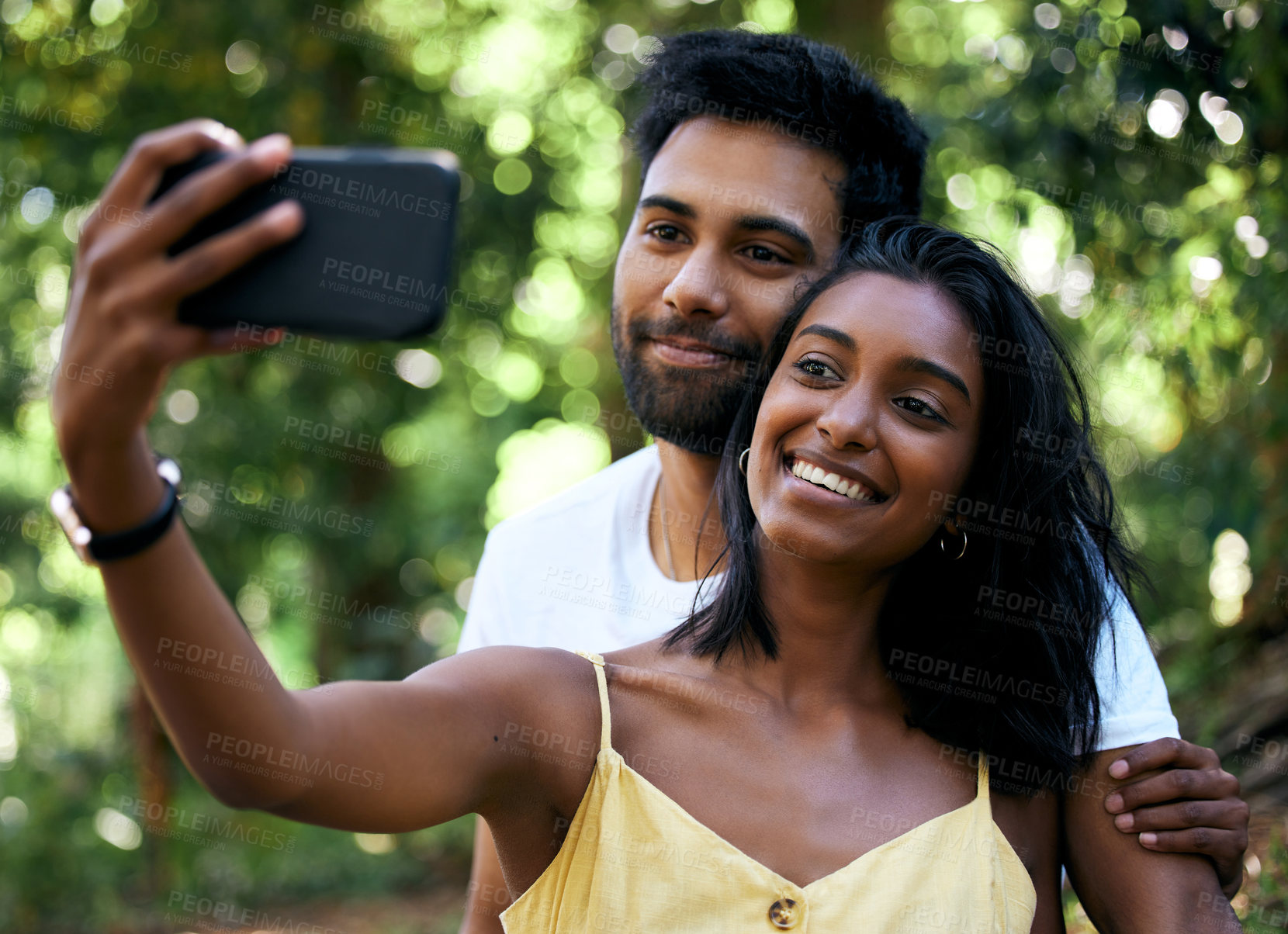 Buy stock photo Smile, selfie and hug in park, garden and of profile picture of Indian couple on social media. Nature, man and woman taking photo on smartphone, life partner and care for love, support or together
