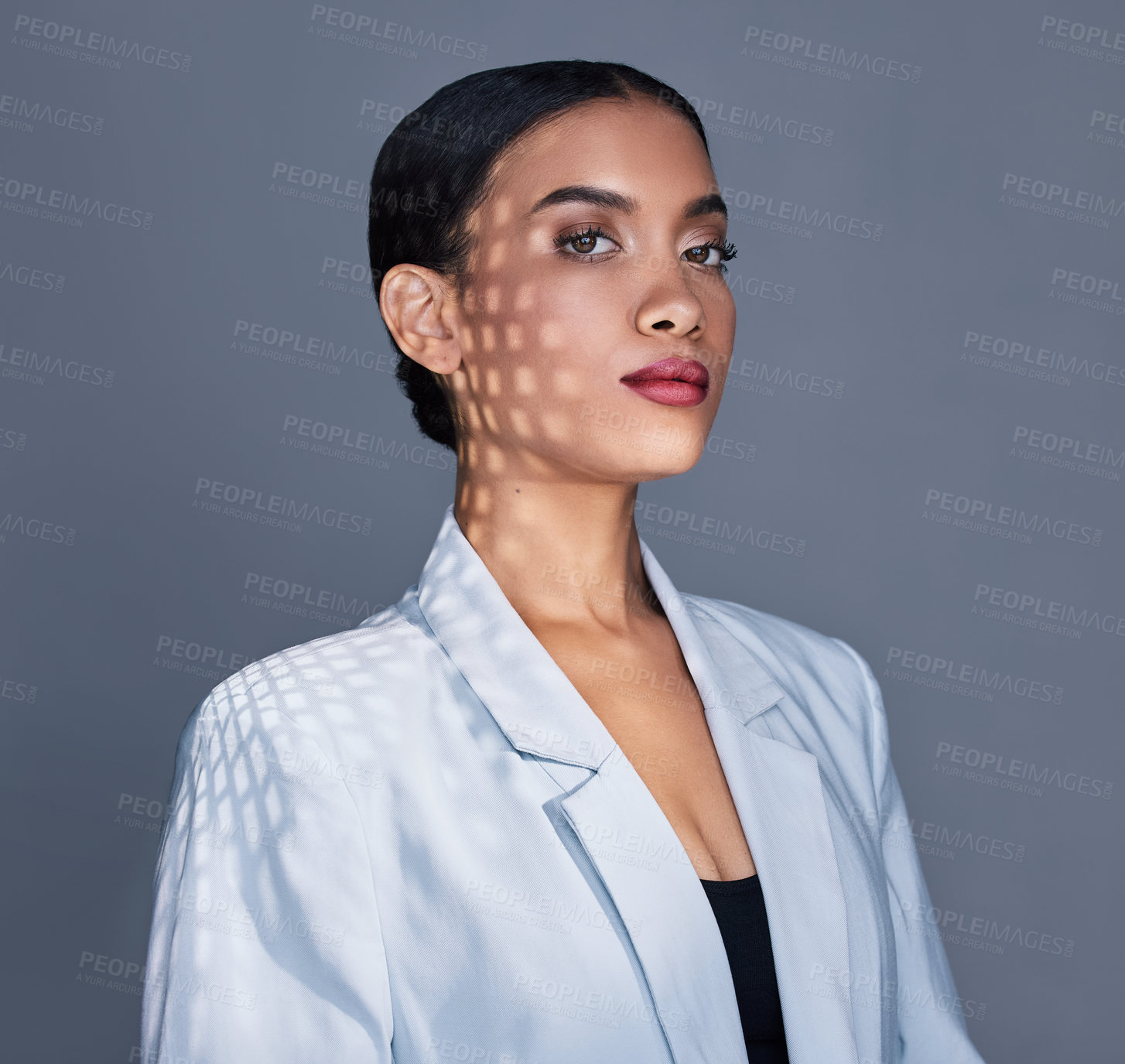 Buy stock photo Shot of a beautiful young woman posing against a grey background