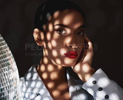 Buy stock photo Shot of a disco light reflecting on a beautiful young woman