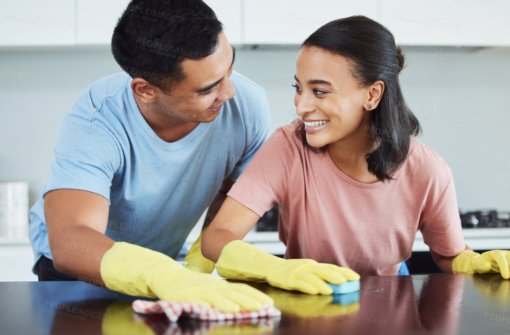 Buy stock photo Shot of a young couple cleaning their kitchen together