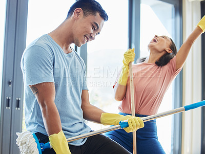 Buy stock photo Couple, cleaning home and singing, dancing and having fun playing with mop guitar and broom. Clean, dance and happy man and woman, singer and chores for housekeeping, hygiene and bonding to music.