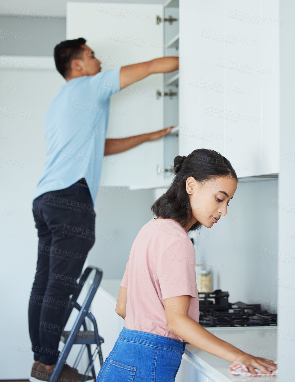 Buy stock photo Shot of a young couple cleaning their kitchen together