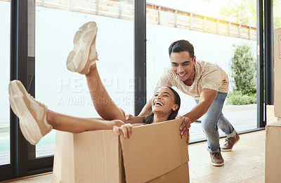 Buy stock photo Shot of a young couple being playful in their new home