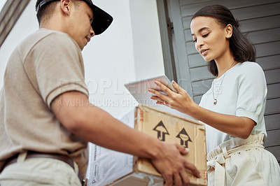 Buy stock photo Shot of a young woman signing for an order with a delivery man using a digital tablet
