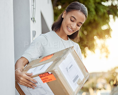 Buy stock photo Shot of a young woman holding her delivery