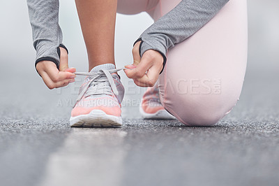 Buy stock photo Closeup shot of an unrecognizable persn tying their shoelaces while exercising
