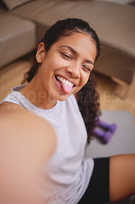 Buy stock photo Shot of an attractive young woman sitting and taking a selfie after her workout in her living room