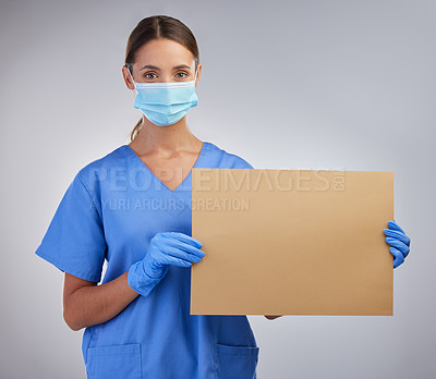 Buy stock photo Shot of a female nurse holding a board for signage against a studio background