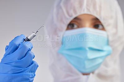 Buy stock photo Shot of a young female nurse holding a needle against a studio background