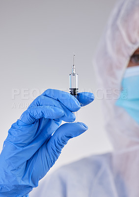 Buy stock photo Shot of a nurse holding a needle against a studio background