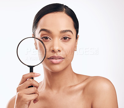 Buy stock photo Shot of a beautiful young woman holding a magnifying glass while posing against a white background