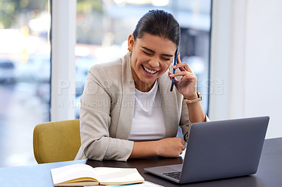 Buy stock photo Shot of an attractive young woman using her cellphone and laptop in a modern office