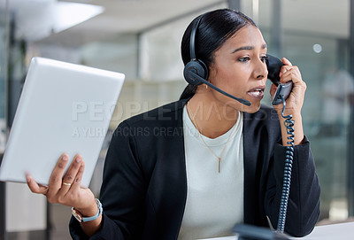 Buy stock photo Shot of an attractive young businesswoman sitting alone and feeling stressed while wearing a headset and using a telephone