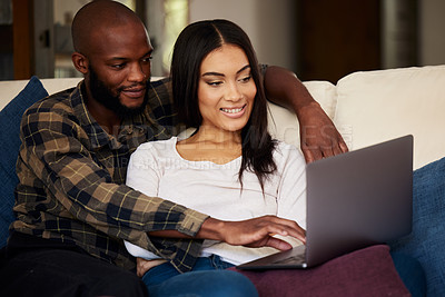 Buy stock photo Shot of a young couple spending quality time together while watching a movie on a laptop at home