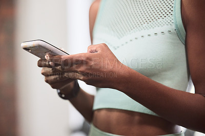 Buy stock photo Shot of an unrecognizable woman using a smartphone during a workout in the gym