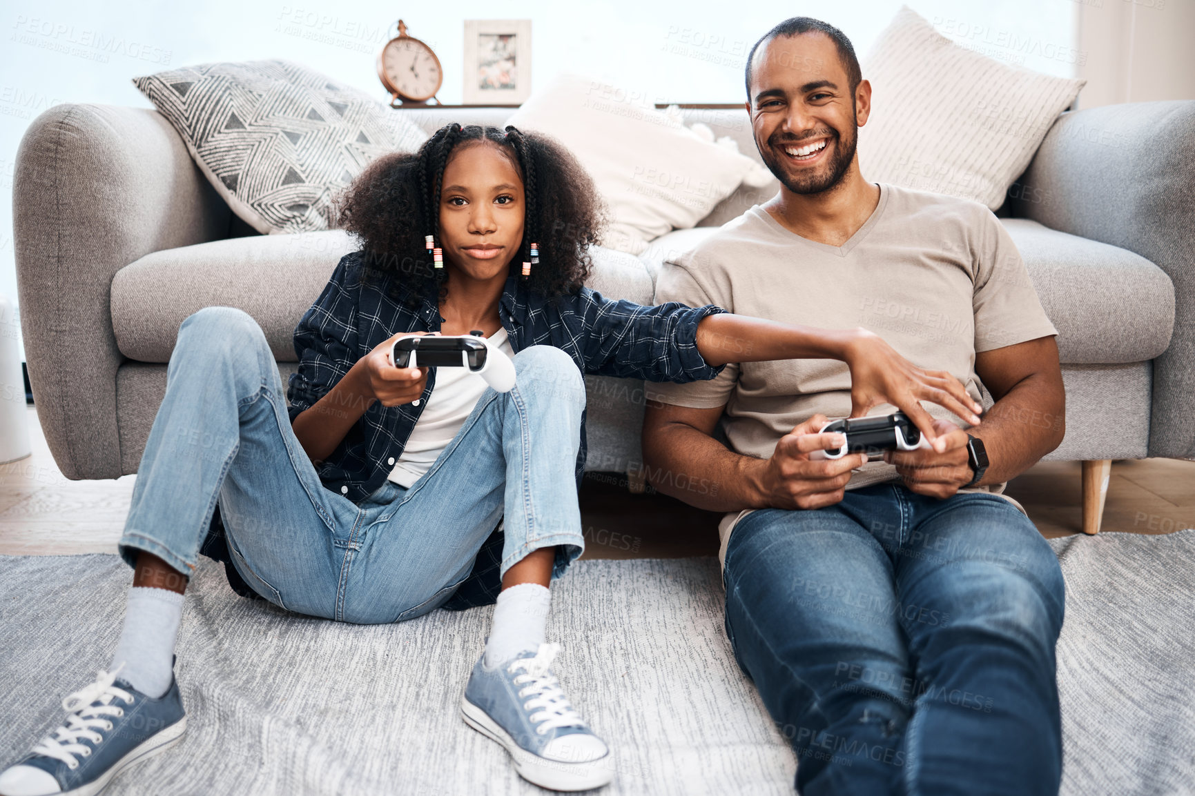 Buy stock photo Shot of a young girl playing video games with her father at home