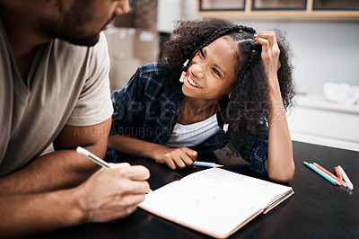 Buy stock photo Shot of a young girl doing a school assignment with her father at home