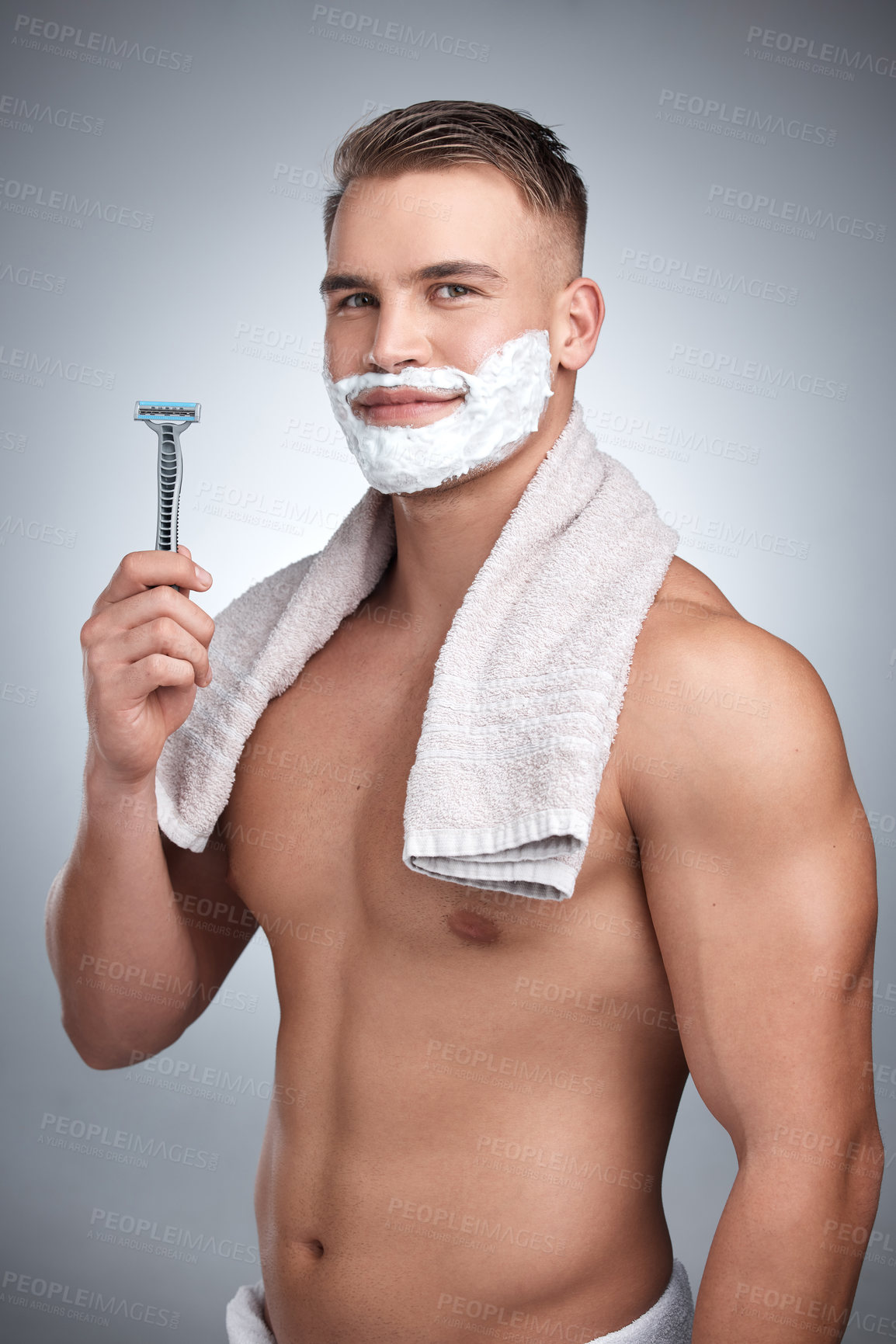 Buy stock photo Portrait, man and razor with hair removal in studio for grooming, shaving cream and towel by backdrop. Male person, body and happy with soap for skincare, beard and facial products by grey background