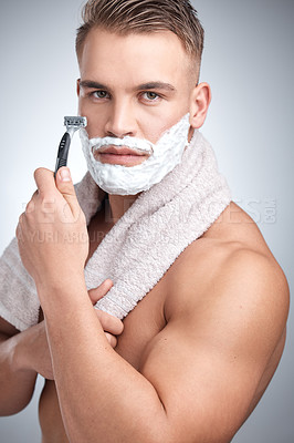 Buy stock photo Man, portrait and razor for hair removal in studio with grooming, shaving cream and towel by backdrop. Male person, body and pride with soap for skincare, beard and facial product by white background