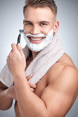 Buy stock photo Portrait, happy man and razor for hair removal in studio with grooming, shaving cream and towel by backdrop. Male person, body and  soap for skincare, beard and facial products by grey background