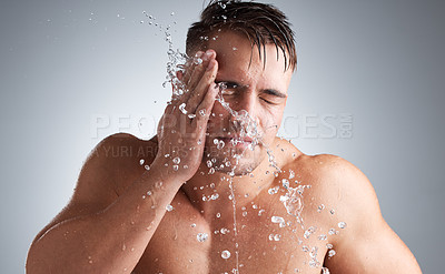 Buy stock photo Washing, studio and man with water, face and morning for splash of body, clean and routine for skincare. Hygiene, glow and person in grey background of bathroom, liquid and relax for bath of shine