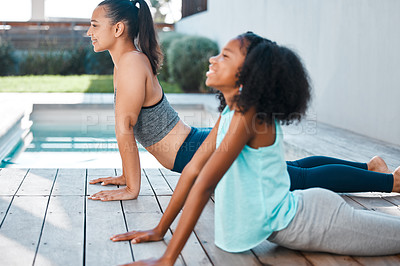 Buy stock photo Shot of a young mother and daughter practicing yoga outside