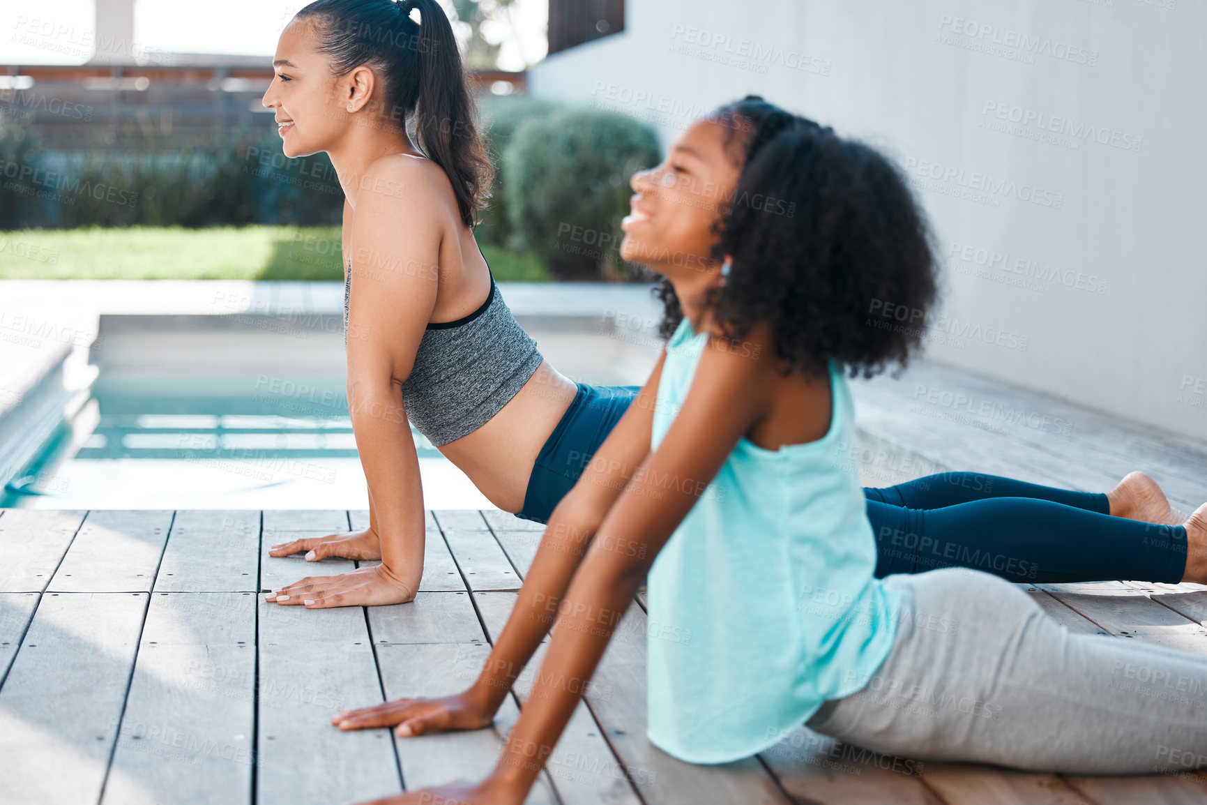 Buy stock photo Shot of a young mother and daughter practicing yoga outside