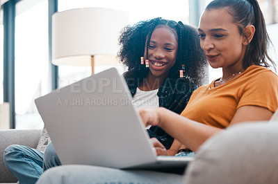 Buy stock photo Shot of a young mother and daughter using a laptop together at home